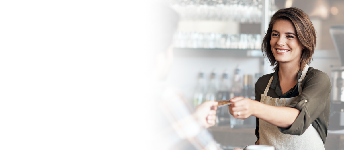 Woman accepting a credit payment at a business that uses the internet to process credit card payments