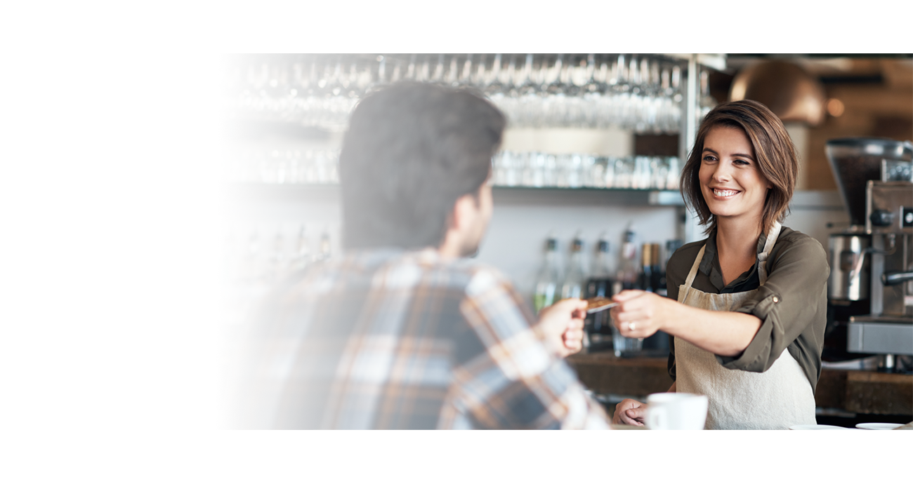 Woman accepting a credit payment at a business that uses the internet to process credit card payments