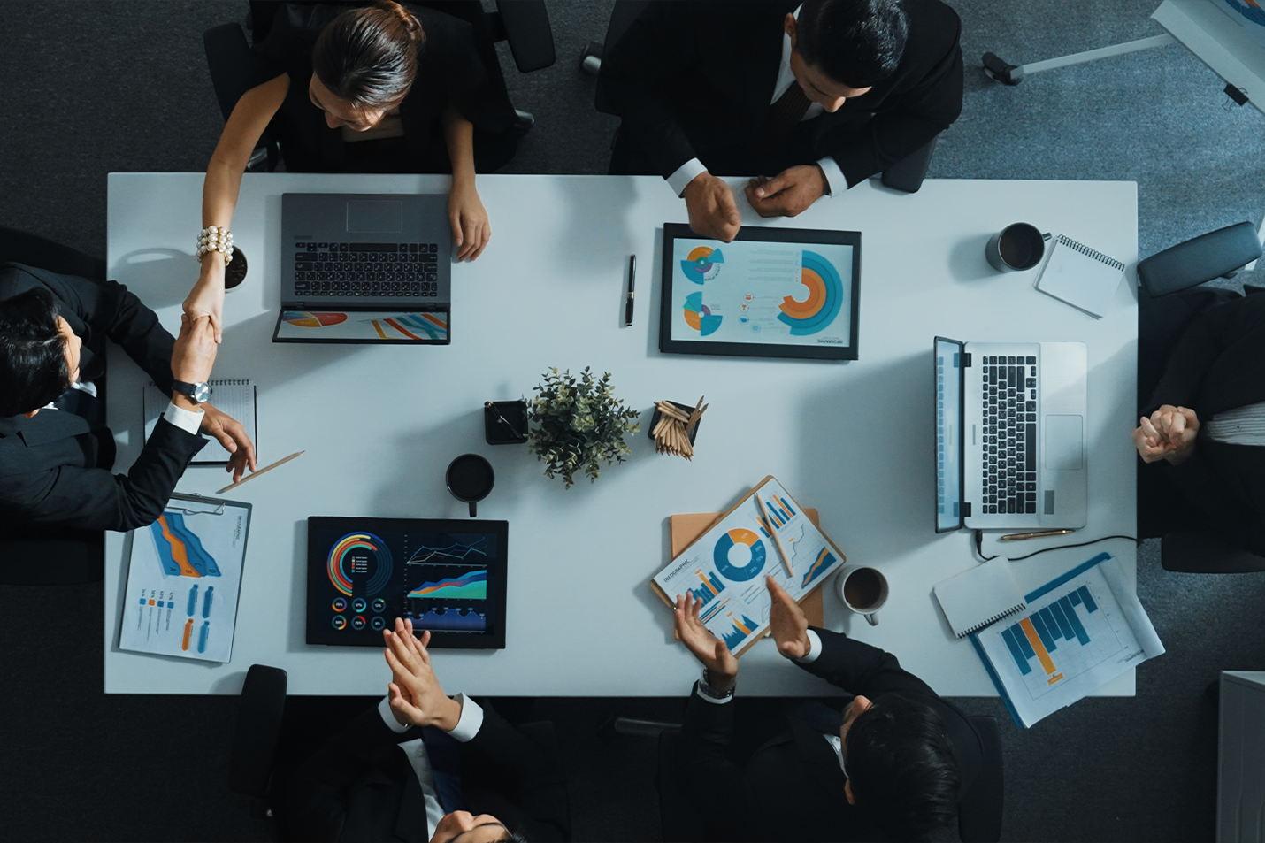 Finance Team manager present growth graph while team shaking hand